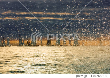 A lot of sailing boats through splashing water at sunset, Sailing regatta in the Gulf of Finland at sunset, hot race of several yachts, teamwork A lot of sailing boats through splashing water at sunset, Sailing regatta in the Gulf of Finland at sunset, hot race of several yachts, teamwork 140763900
