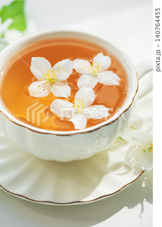 Jasmine tea in white cup with floating flowers Jasmine tea in white cup with floating flowers 140764455