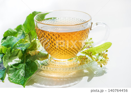 Linden tea cup with fresh linden flowers and leaves Linden tea cup with fresh linden flowers and leaves 140764456