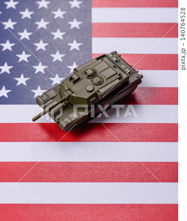 A tank on the US flag as a conceptual backdrop representing defense and preparation against attack 140764528