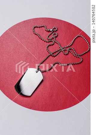 A dog tag on the Japanese flag, serving as a conceptual backdrop representing defense 140764582