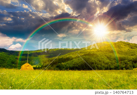 sunset over rural fields near pikui mountain in summertime. beautiful view of agricultural area. gorgeous mountain ridge with haystack on a grassy pasture. summer scenery. weather with rainbow sunset over rural fields near pikui mountain in summertime. beautiful view of agricultural area. gorgeous mountain ridge with haystack on a grassy pasture. summer scenery. weather with rainbow 140764713
