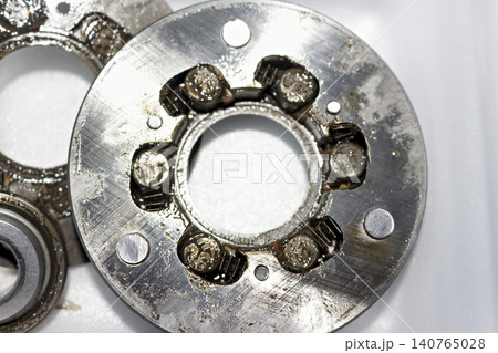 Disassembled electric bicycle motor freewheel clutch mechanism featuring worn metallic rollers covered in old dirty lubricant grease during maintenance repair process closeup top view Disassembled electric bicycle motor freewheel clutch mechanism featuring worn metallic rollers covered in old dirty lubricant grease during maintenance repair process closeup top view 140765028