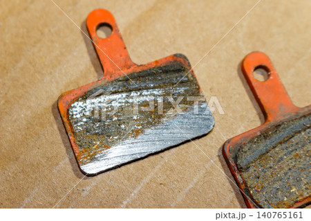 Worn out bicycle brake pads showing metal backing, indicating total wear and need for immediate replacement Worn out bicycle brake pads showing metal backing, indicating total wear and need for immediate replacement 140765161