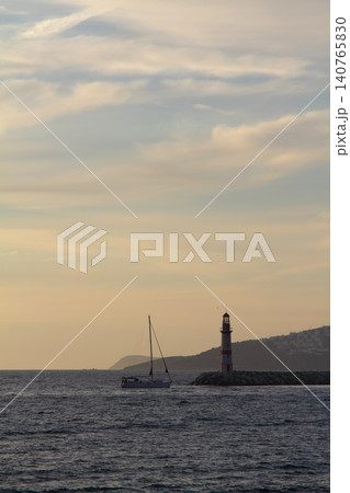 Seascape at sunshine. Lighthouse and sailings on the coast. Seaside town of Turgutreis and spectacular sunshine Seascape at sunshine. Lighthouse and sailings on the coast. Seaside town of Turgutreis and spectacular sunshine 140765830