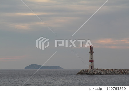 Seascape at sunshine. Lighthouse and sailings on the coast. Seaside town of Turgutreis and spectacular sunshine Seascape at sunshine. Lighthouse and sailings on the coast. Seaside town of Turgutreis and spectacular sunshine 140765860