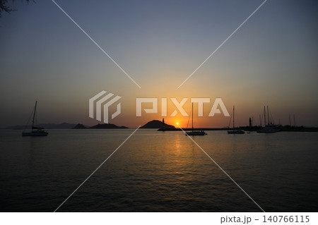 Seascape at sunshine. Lighthouse and sailings on the coast. Seaside town of Turgutreis and spectacular sunshine 140766115
