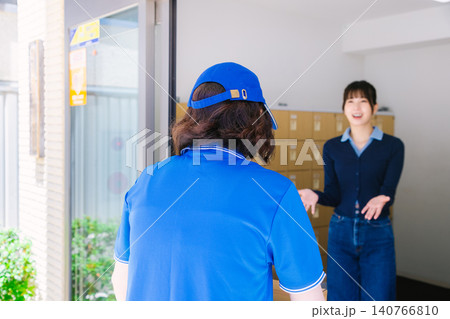 宅配便の女性配達員 と荷物を受け取る女性 140766810