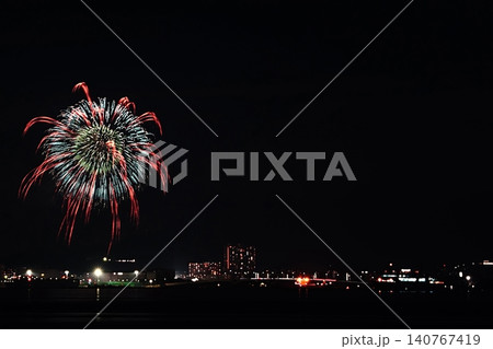海辺の夜空を彩る青と赤の創作花火 140767419