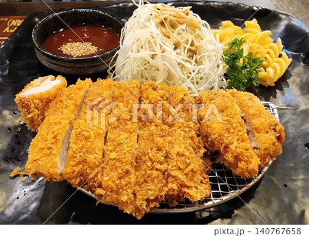 Japanese Crispy Fried Pork Cutlet Tonkatsu with Cabbage and Dipping Sauce 140767658