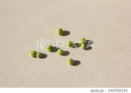 It is a pea lying on the wooden floor. It is a pea lying on the wooden floor. 140768195