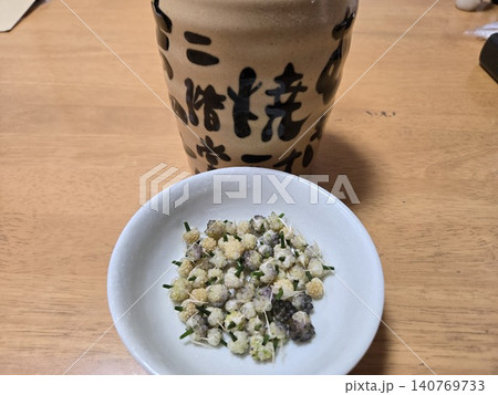 焼酎のボトルと、おつまみのノビルのムカゴの塩ゆで 140769733