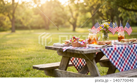 Rustic picnic table setting with american flags and summer fruit spread patriotic celebration sunlight afternoon refreshment chequered gathering community vacation relaxation beverage 140770040