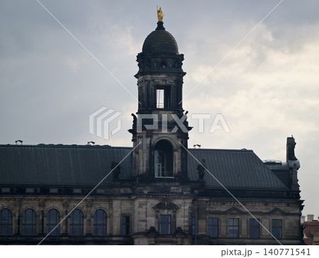Storm clouds shadow ornate civic structure. Clouds brew over ageold architectural landmark towering high Storm clouds shadow ornate civic structure. Clouds brew over ageold architectural landmark towering high 140771541