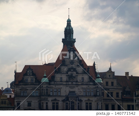 Clouded sky cast over heritage buildings featuring steep roofs and ornate architectural details 140771542