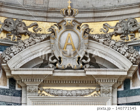 Majestic royal symbol gracing ornate historic palace entrance illuminated by natural sunlight Majestic royal symbol gracing ornate historic palace entrance illuminated by natural sunlight 140771545