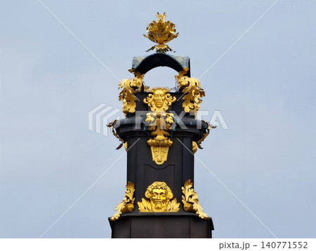 Sophisticated decorative artwork showcasing mask with laurel motifs and elaborately sculpted columns Sophisticated decorative artwork showcasing mask with laurel motifs and elaborately sculpted columns 140771552