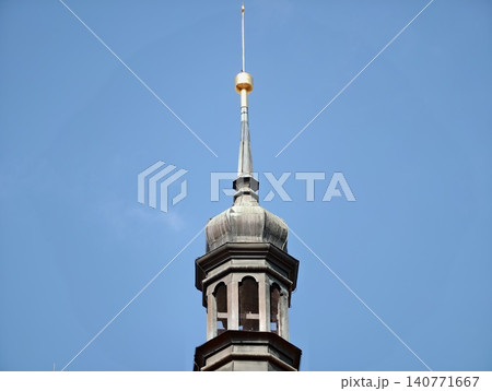 European historic church silhouette. Weathered copper details adorn ancient ecclesiastical tower European historic church silhouette. Weathered copper details adorn ancient ecclesiastical tower 140771667