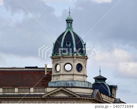 Graceful dome with copper roof. Imposing civic building featuring round oculus and copper dome Graceful dome with copper roof. Imposing civic building featuring round oculus and copper dome 140771694