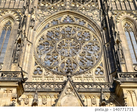 Bright stained glass. Radiant colored window surrounded by elaborate arches and sculpted portico details Bright stained glass. Radiant colored window surrounded by elaborate arches and sculpted portico details 140771715