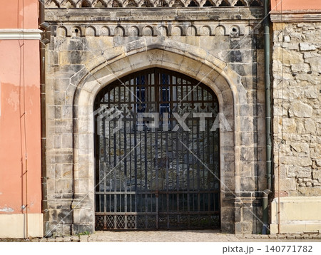 Decorative historic entrance. Vintage courtyard with carved lintel and peach hues evokes heritage 140771782