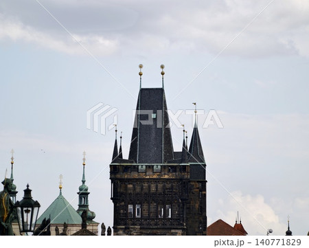 Medieval stone structure silhouette. Ancient tower with copper ornamentation and cloudy backdrop Medieval stone structure silhouette. Ancient tower with copper ornamentation and cloudy backdrop 140771829