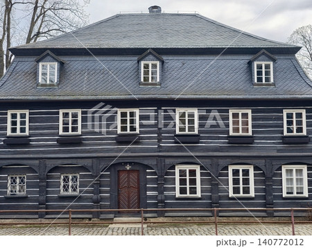 Vintage house facade. Oldfashioned wooden house featuring balanced window placement and dormer roof Vintage house facade. Oldfashioned wooden house featuring balanced window placement and dormer roof 140772012