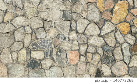The wall is decorated with decorative stone of different sizes and colors. Beautiful texture of stone masonry with veins. 140772269