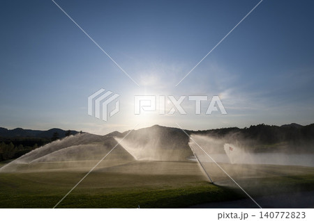 ゴルフコースのグリーンで水撒きスプリンクラーが一斉に噴水する朝の風景 140772823