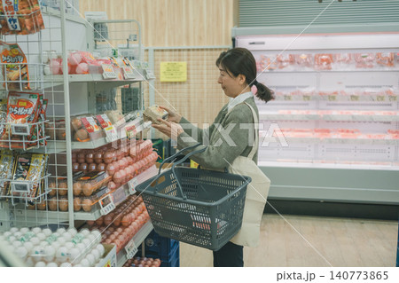 スーパーのたまご売り場で卵の値段に悲しい表情の中高年女性客 スーパーのたまご売り場で卵の値段に悲しい表情の中高年女性客 140773865