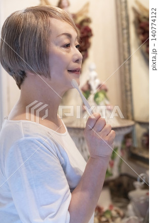 洗面台で歯磨きをするシニア女性 140774122