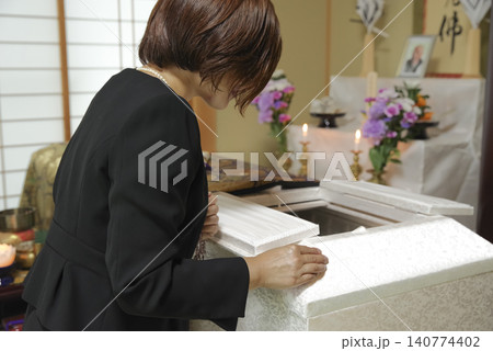 葬儀で故人との別れを惜しむ女性 140774402