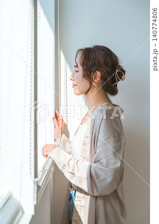 リビングの窓辺に立つおしゃれな女性 140774806