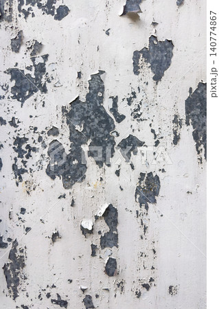 A weathered white painted metal surface shows significant peeling and flaking A weathered white painted metal surface shows significant peeling and flaking 140774867