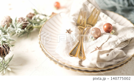 Elegant Christmas Table Setting with Gold Cutlery and Festive Ornaments Elegant Christmas Table Setting with Gold Cutlery and Festive Ornaments 140775002