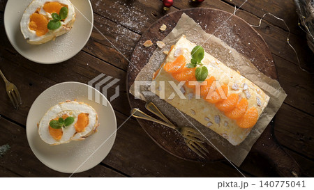 Mandarin orange meringue roll cake on rustic wooden board 140775041
