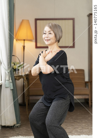 リビングでストレッチをするシニア女性 140775165