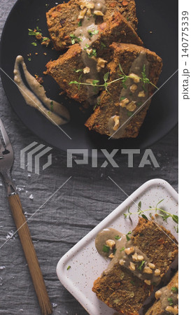 Slices of lentil loaf drizzled with a creamy sauce and garnished with walnuts and fresh herbs Slices of lentil loaf drizzled with a creamy sauce and garnished with walnuts and fresh herbs 140775339