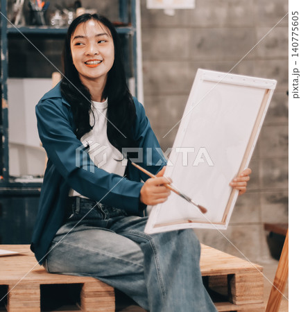 Female artist wears black hat posing near picture indoor the studio Female artist wears black hat posing near picture indoor the studio 140775605
