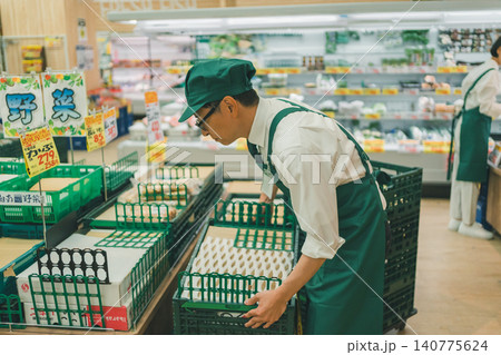 スーパーマーケットの野菜売り場で陳列作業をする店員 スーパーマーケットの野菜売り場で陳列作業をする店員 140775624