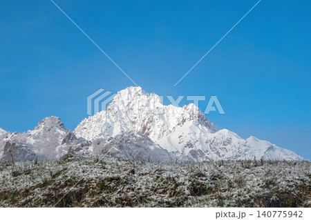 Amazing snow-capped peak dominates the frame. Blue sky Amazing snow-capped peak dominates the frame. Blue sky 140775942