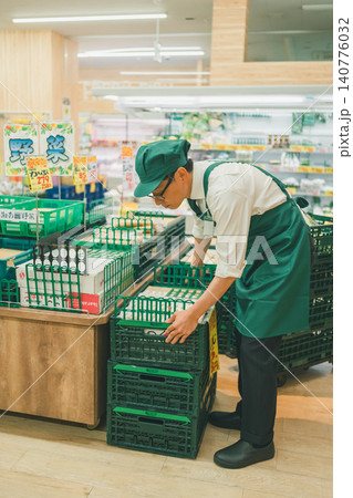 野菜売り場で売り場作りをするスーパーの男性店員 140776032