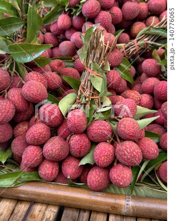 Fresh red lychee fruit bunches with green leaves 140776065
