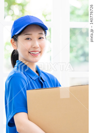 引越し ダンボールを箱を運ぶ女性スタッフ 引越し ダンボールを箱を運ぶ女性スタッフ 140776726