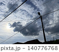 Utility Pole And Power Lines Under Cloudy Sky With Sunbeams 140776768