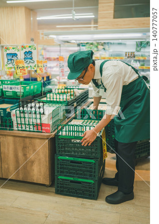 食品スーパーの野菜売り場で作業する店員たち 食品スーパーの野菜売り場で作業する店員たち 140777057