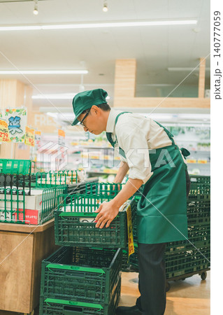 食品スーパーの野菜売り場でコンテナを扱う店員 食品スーパーの野菜売り場でコンテナを扱う店員 140777059