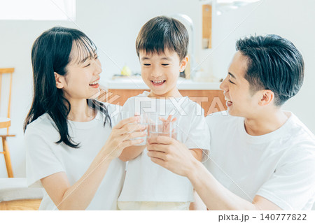 リビングで水を飲む若い家族 リビングで水を飲む若い家族 140777822