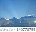 The image depicts a breathtaking view of the sky with numerous fluffy white clouds scattered across it The sun is shining brightly from the top right 140778755