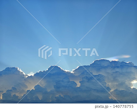 The image depicts a breathtaking view of the sky with numerous fluffy white clouds scattered across it The sun is shining brightly from the top right The image depicts a breathtaking view of the sky with numerous fluffy white clouds scattered across it The sun is shining brightly from the top right 140778755